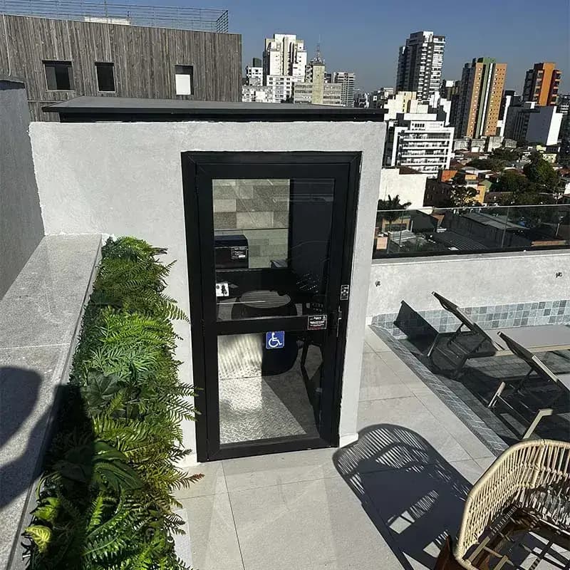 Elevador residencial panorâmico instalado em cobertura, com vista para a cidade