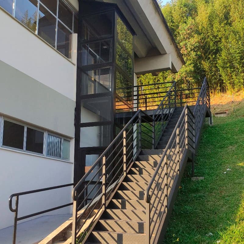 Enclausuramento hidráulico em estrutura metálica e vidro junto a escada externa