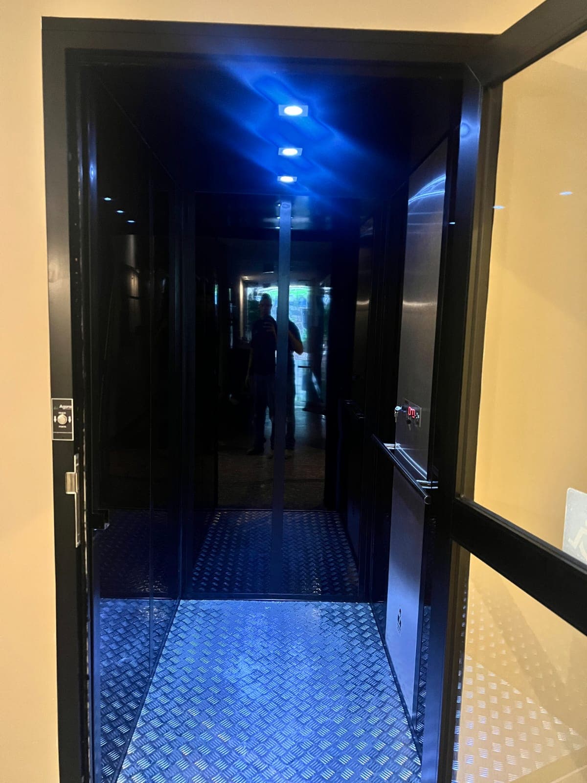 Interior de cabine comercial fechada com teto iluminado em LED e corrimão em aço inox