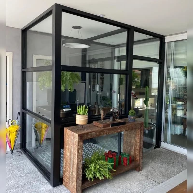 Plataforma hidráulica cabinada em vidro e estrutura preta instalada em entrada residencial