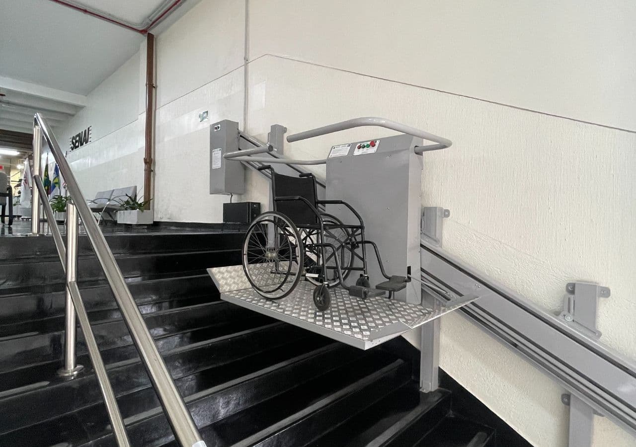 Plataforma de acessibilidade para escada com cadeira de rodas posicionada sobre os degraus